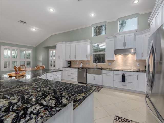 kitchen with white cabinetry, sink, backsplash, vaulted ceiling, and appliances with stainless steel finishes