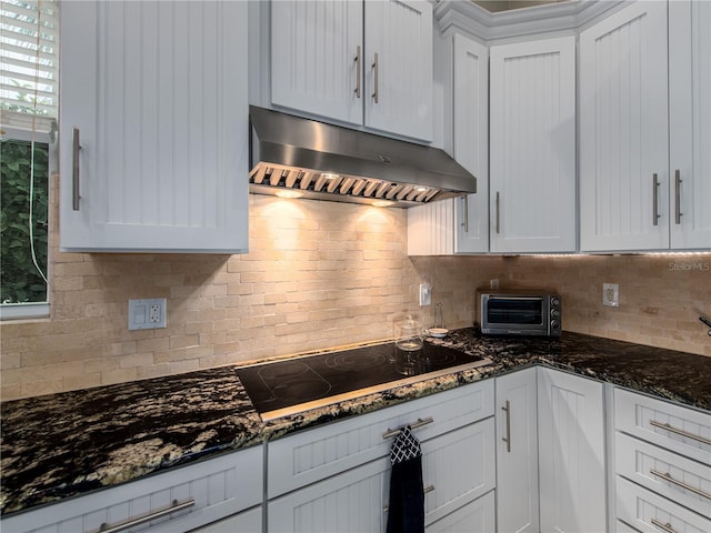 4709 Corsage Dr, Lutz, FL 33558 - kitchen with exhaust hood, black electric cooktop, tasteful backsplash, white cabinetry, and dark stone countertops