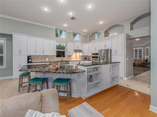 4709 Corsage Dr, Lutz, FL 33558 - kitchen with appliances with stainless steel finishes, open shelves, crown molding, white cabinetry, and tasteful backsplash