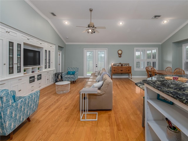 living room with plenty of natural light, ceiling fan, light hardwood / wood-style flooring, and lofted ceiling