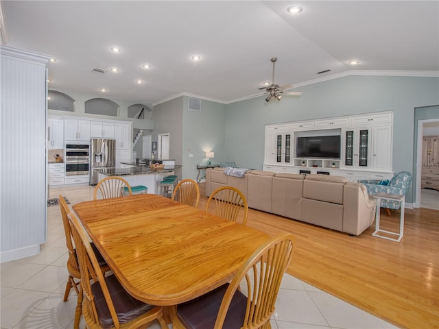 tiled dining room featuring crown molding, ceiling fan, and lofted ceiling