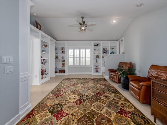 sitting room featuring ceiling fan, built in features, lofted ceiling, and light wood-type flooring