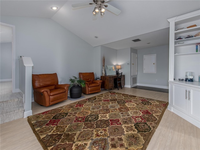 living area with ceiling fan, wood-type flooring, and lofted ceiling