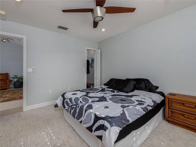 bedroom featuring ceiling fan and a textured ceiling