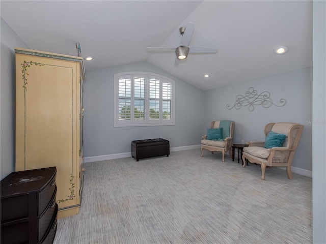 sitting room with ceiling fan, light carpet, and vaulted ceiling