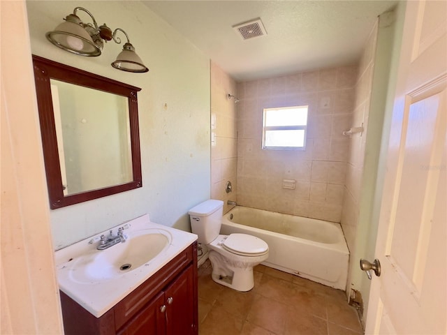 full bathroom with tile patterned floors, vanity, tiled shower / bath combo, and toilet