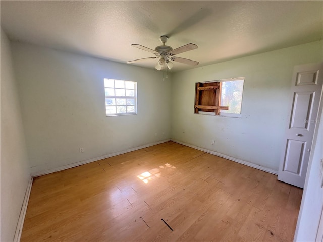 empty room with ceiling fan and light wood-type flooring