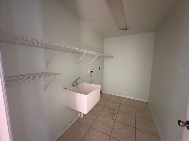 laundry area with hookup for an electric dryer, hookup for a washing machine, light tile patterned floors, and sink