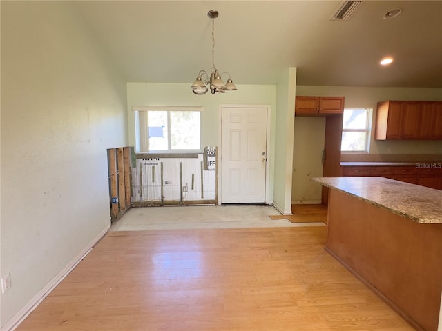 kitchen with pendant lighting, light wood-type flooring, and an inviting chandelier