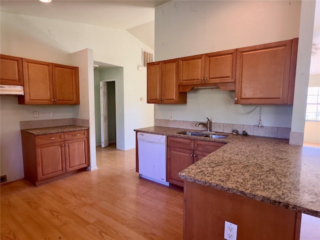 kitchen featuring kitchen peninsula, white dishwasher, vaulted ceiling, sink, and light hardwood / wood-style floors