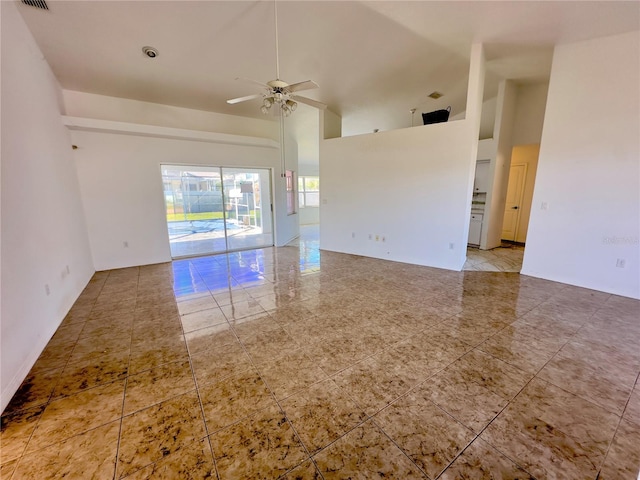 unfurnished room featuring ceiling fan and a high ceiling