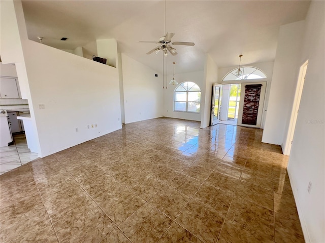 unfurnished living room with ceiling fan and high vaulted ceiling