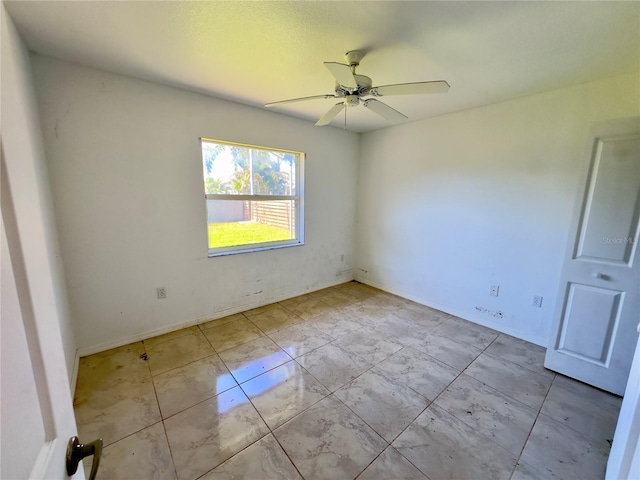 tiled spare room with ceiling fan