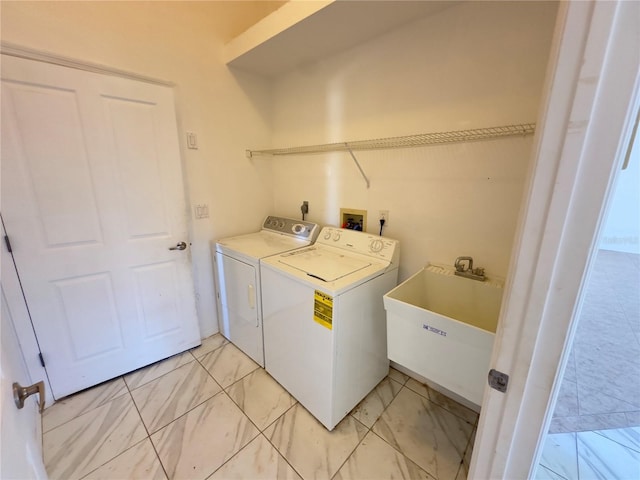 clothes washing area with separate washer and dryer and sink