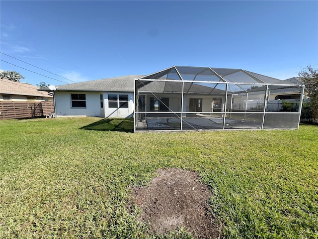 rear view of house with a yard and a lanai