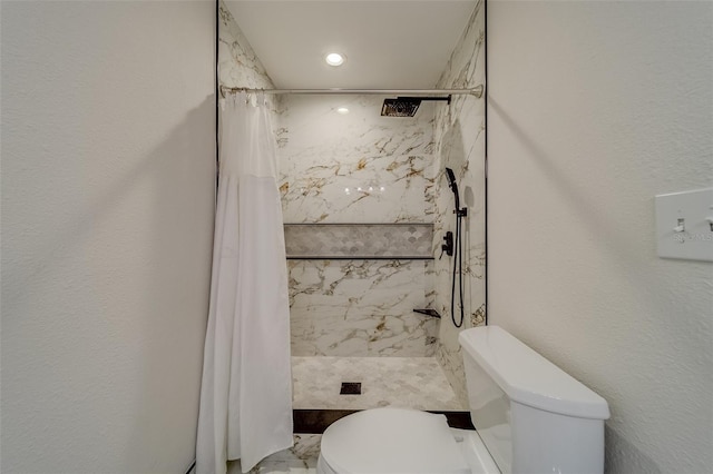 bathroom featuring toilet and curtained shower