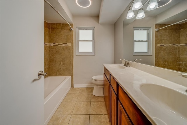 full bathroom featuring toilet, vanity, tile patterned floors, and tiled shower / bath