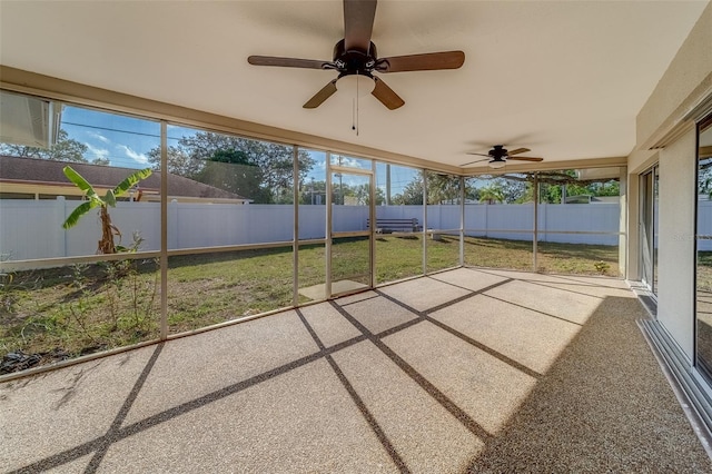 unfurnished sunroom featuring ceiling fan