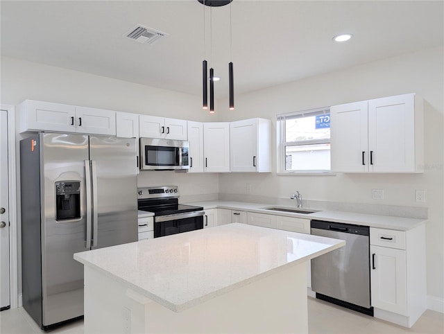 kitchen with sink, white cabinetry, a center island, hanging light fixtures, and stainless steel appliances