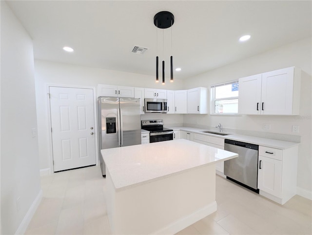 kitchen featuring sink, white cabinetry, hanging light fixtures, stainless steel appliances, and a center island