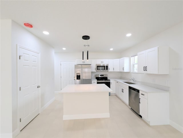 kitchen featuring decorative light fixtures, sink, white cabinets, a center island, and stainless steel appliances