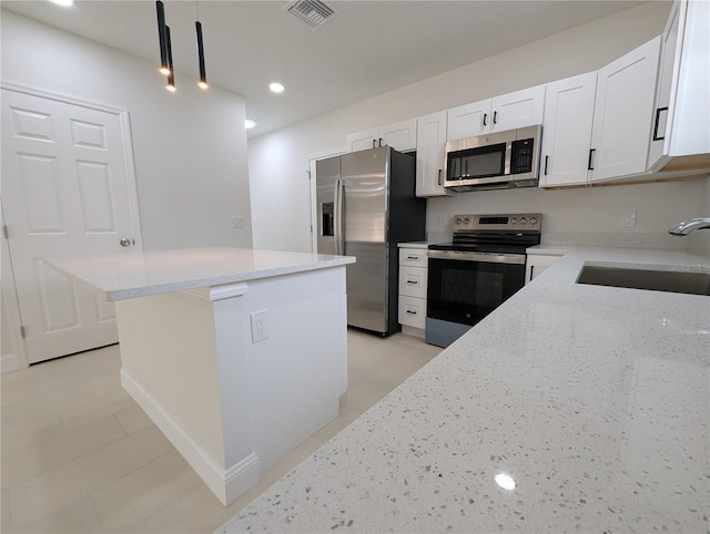 kitchen with sink, decorative light fixtures, stainless steel appliances, light stone countertops, and white cabinets