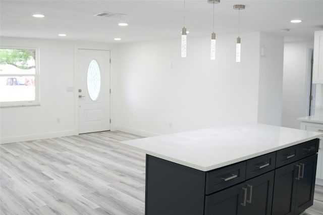 interior space featuring pendant lighting, light wood-type flooring, and a kitchen island