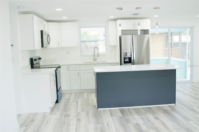 kitchen featuring white cabinetry, pendant lighting, stainless steel appliances, and sink