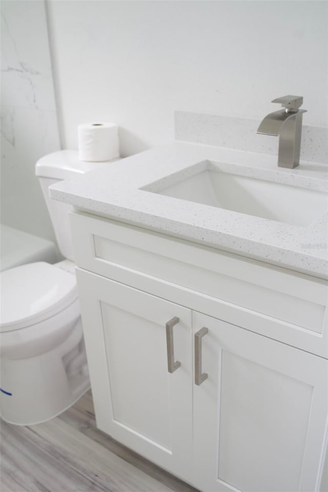 bathroom featuring hardwood / wood-style floors, vanity, and toilet