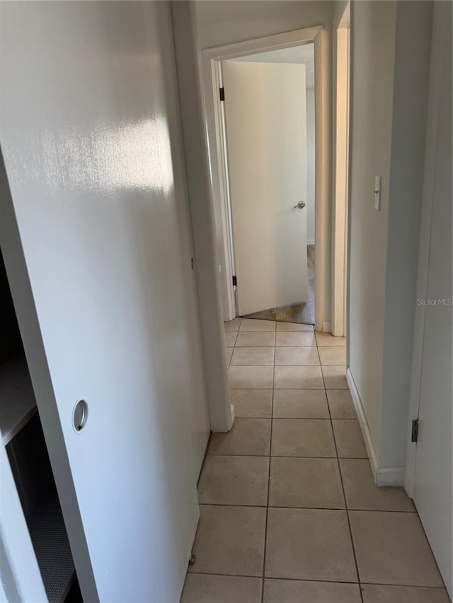 hall with light tile patterned floors