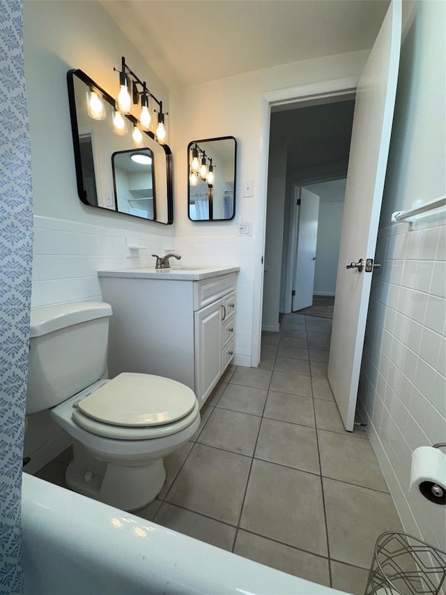 bathroom featuring tile patterned floors, vanity, tile walls, and toilet