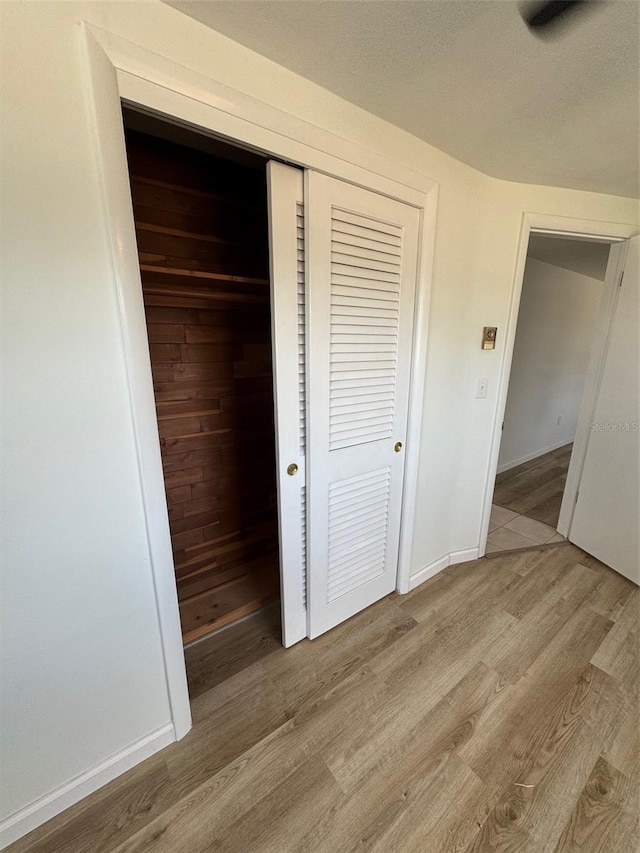 unfurnished bedroom with light wood-type flooring and a closet