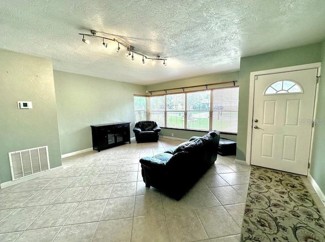 living room with a textured ceiling and rail lighting