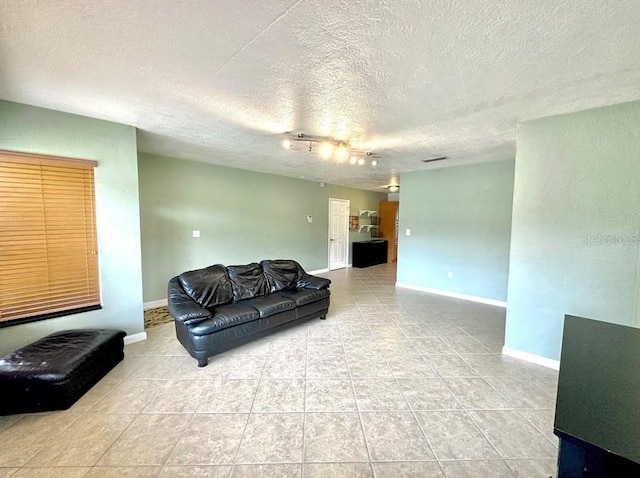 living room with rail lighting, light tile patterned flooring, and a textured ceiling