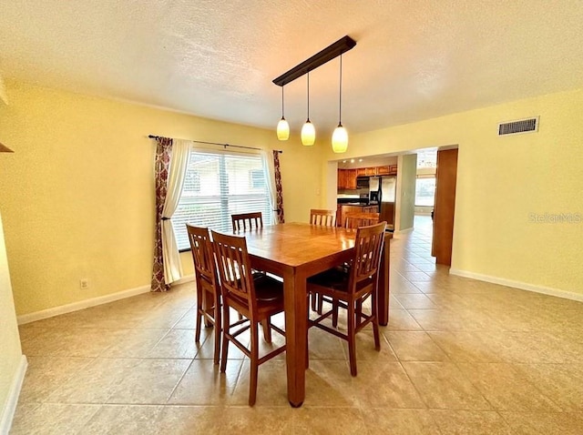 tiled dining room with a textured ceiling