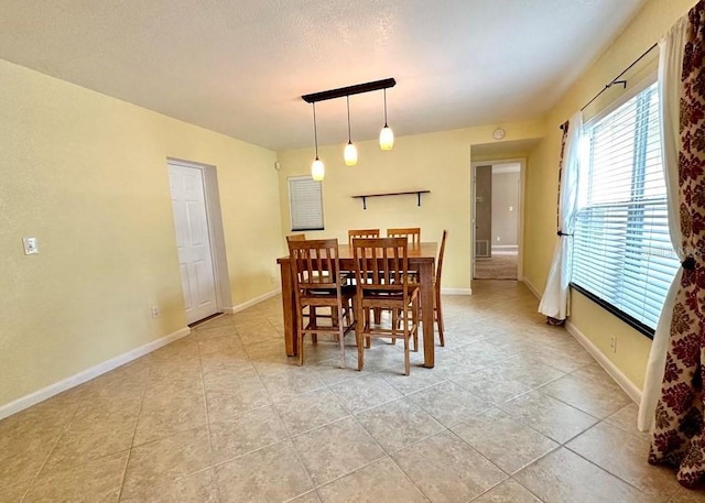 dining area with light tile patterned floors and a textured ceiling