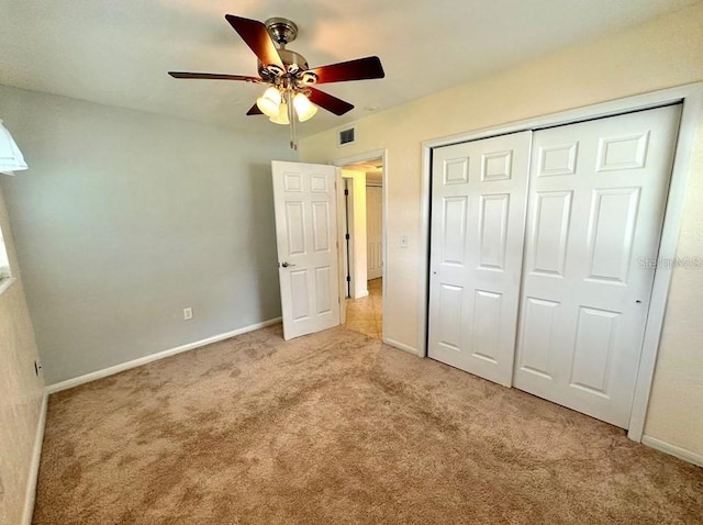 unfurnished bedroom with ceiling fan, a closet, and light colored carpet