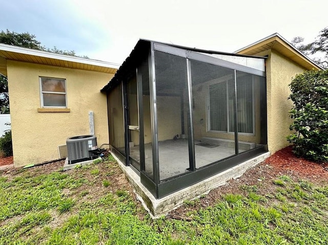 view of home's exterior featuring a sunroom and central air condition unit