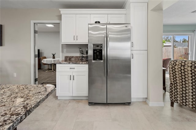 kitchen with white cabinets, dark stone counters, and stainless steel refrigerator with ice dispenser