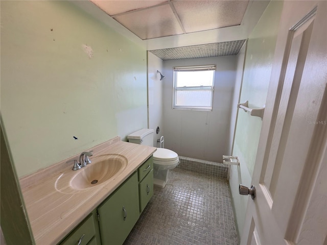 bathroom with toilet, tile patterned floors, and vanity