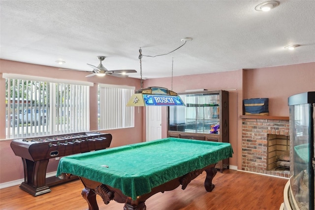 rec room with ceiling fan, a fireplace, billiards, and hardwood / wood-style flooring