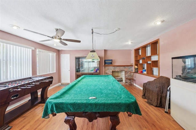 rec room with a fireplace, hardwood / wood-style floors, a textured ceiling, and billiards