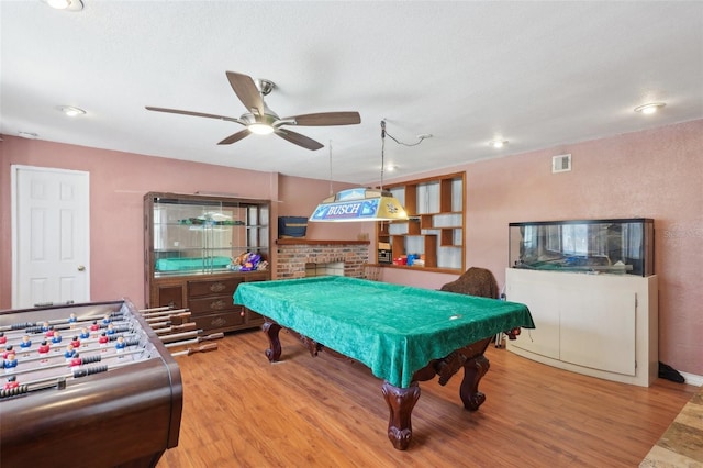 playroom with hardwood / wood-style floors, ceiling fan, billiards, and a brick fireplace