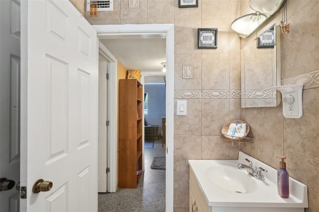 bathroom with vanity and tile walls