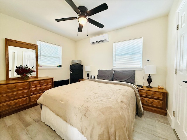 bedroom featuring a wall mounted air conditioner, ceiling fan, multiple windows, and light hardwood / wood-style flooring