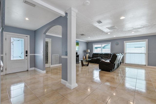 living room with light tile patterned floors, decorative columns, and crown molding