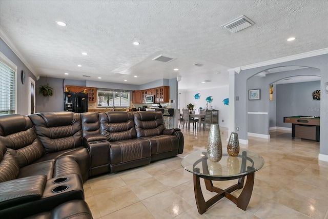 living room with a textured ceiling and crown molding