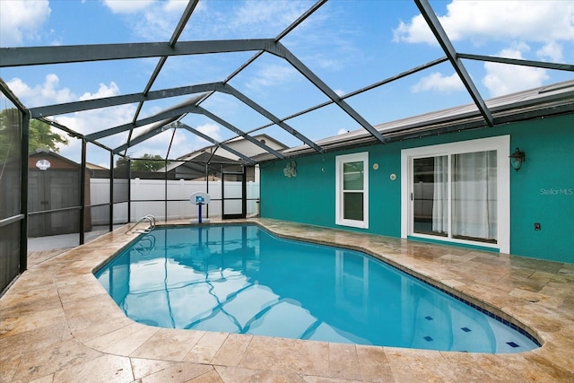 view of swimming pool with glass enclosure and a patio area