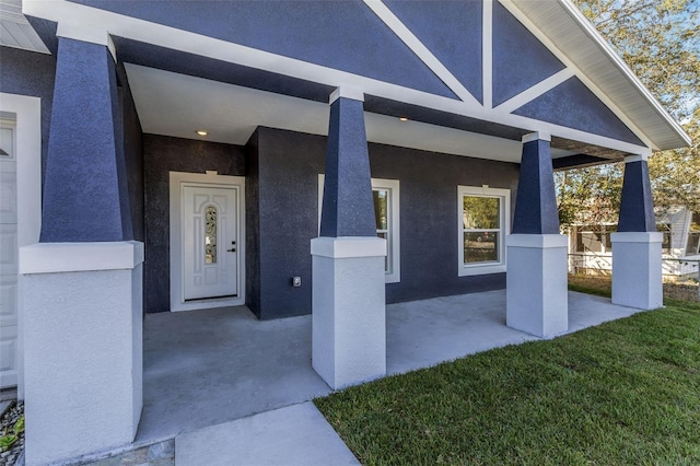 property entrance featuring a patio and a yard