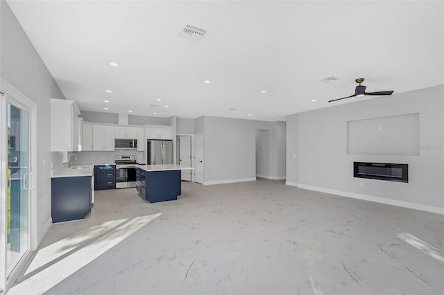 unfurnished living room with ceiling fan and sink